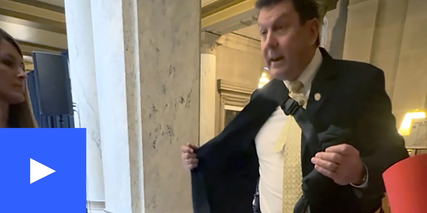 Indiana state rep. Jim Lucas opening his jacket to flash gun