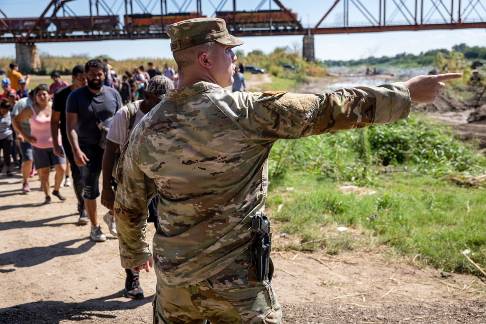 John Moore / Getty Images file | Bildquelle: NBC News © Ein Soldat der texanischen Nationalgarde weist Einwanderer auf einen Kontrollpunkt der US-Grenzpatrouille hin, nachdem sie 2023 die Grenze überquert haben. | Bilder sind in der Regel urheberrechtlich geschützt
