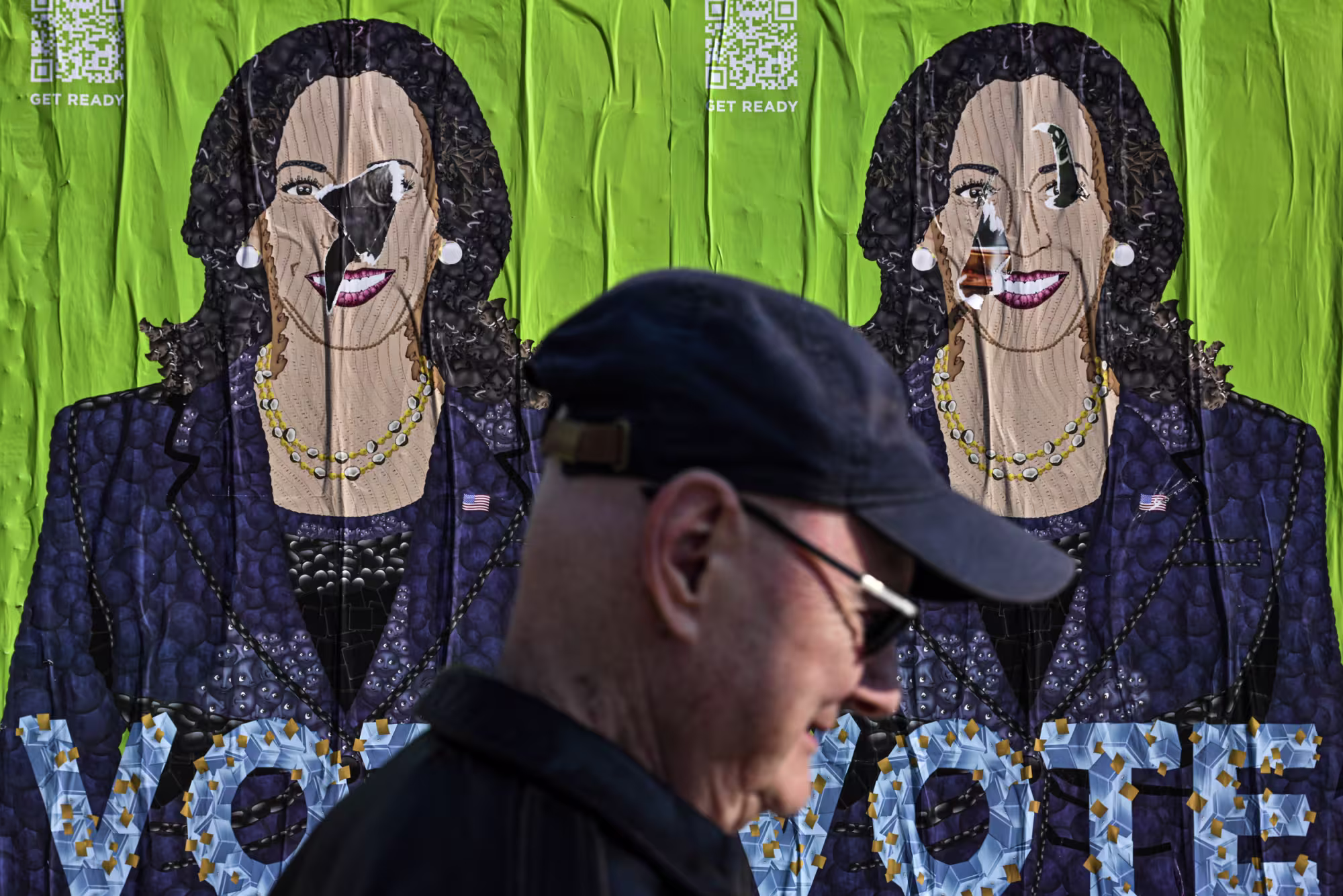 A pedestrian passes by a Kamala Harris poster in Philadelphia on Oct. 12.