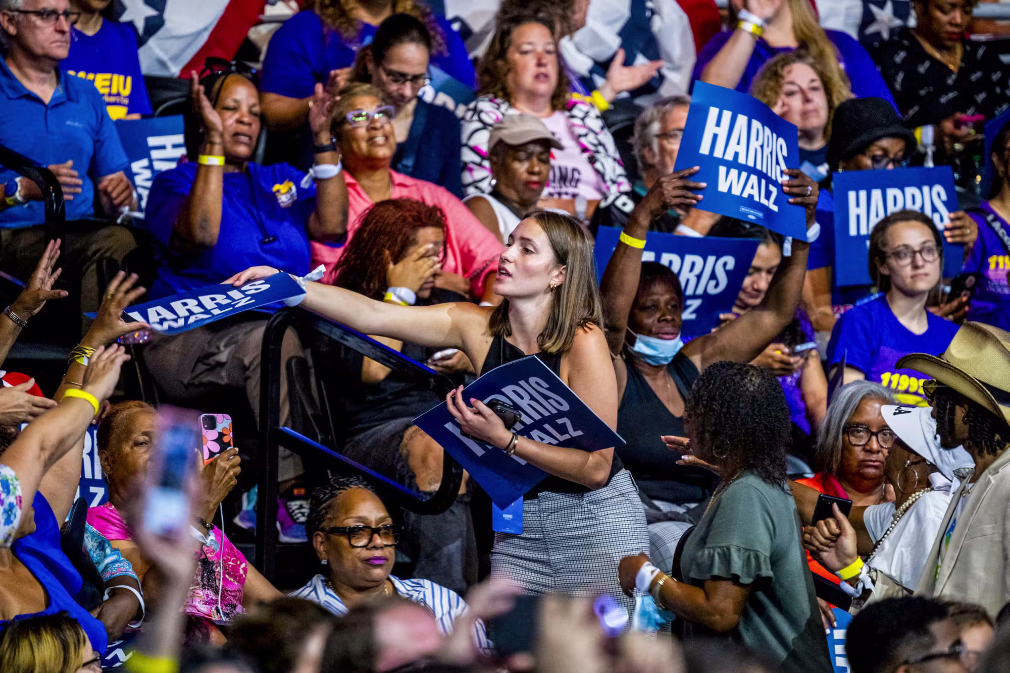A volunteer distributes signs during a campaign rally at Temple University in Philadelphia