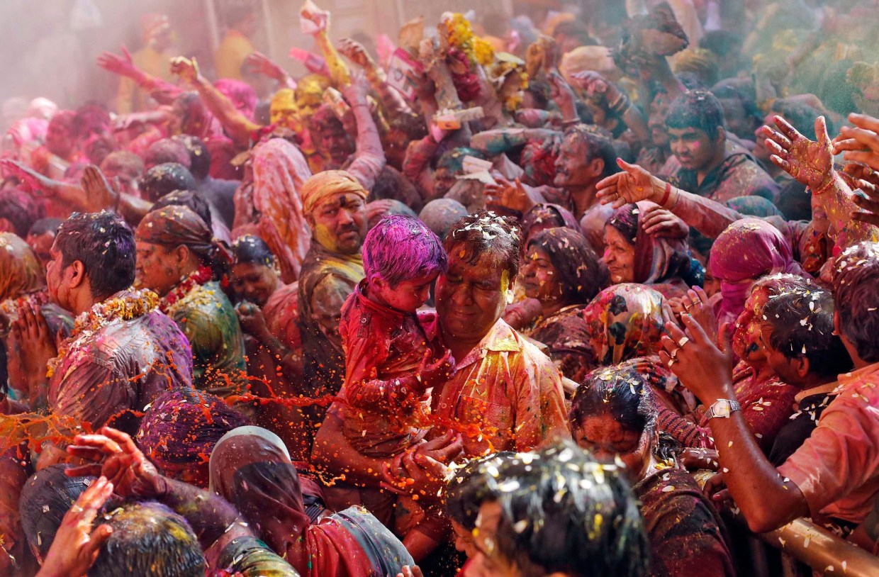 Image: Hindu devotees react as priests throw coloured water on them during Holi celebrations at the Bankey Bihari temple in Vrindavan