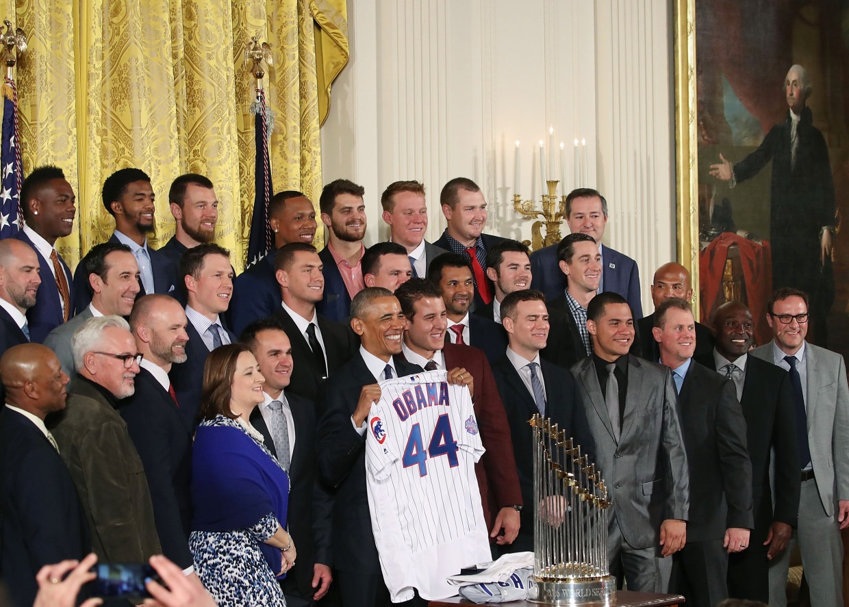 President Barack Obama smiles as Chicago Cubs first baseman Anthony Rizzo  presents him with a 'Chicago' jersey during a ceremony to honor the Cubs in  the East Room of the White House