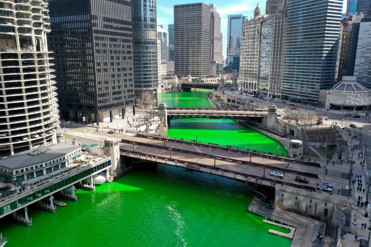 Chicago River is dyed green for St. Patrick's Day. Shadows of bridge  holding crowds of people and flags are imprinted on water surface Stock  Photo - Alamy