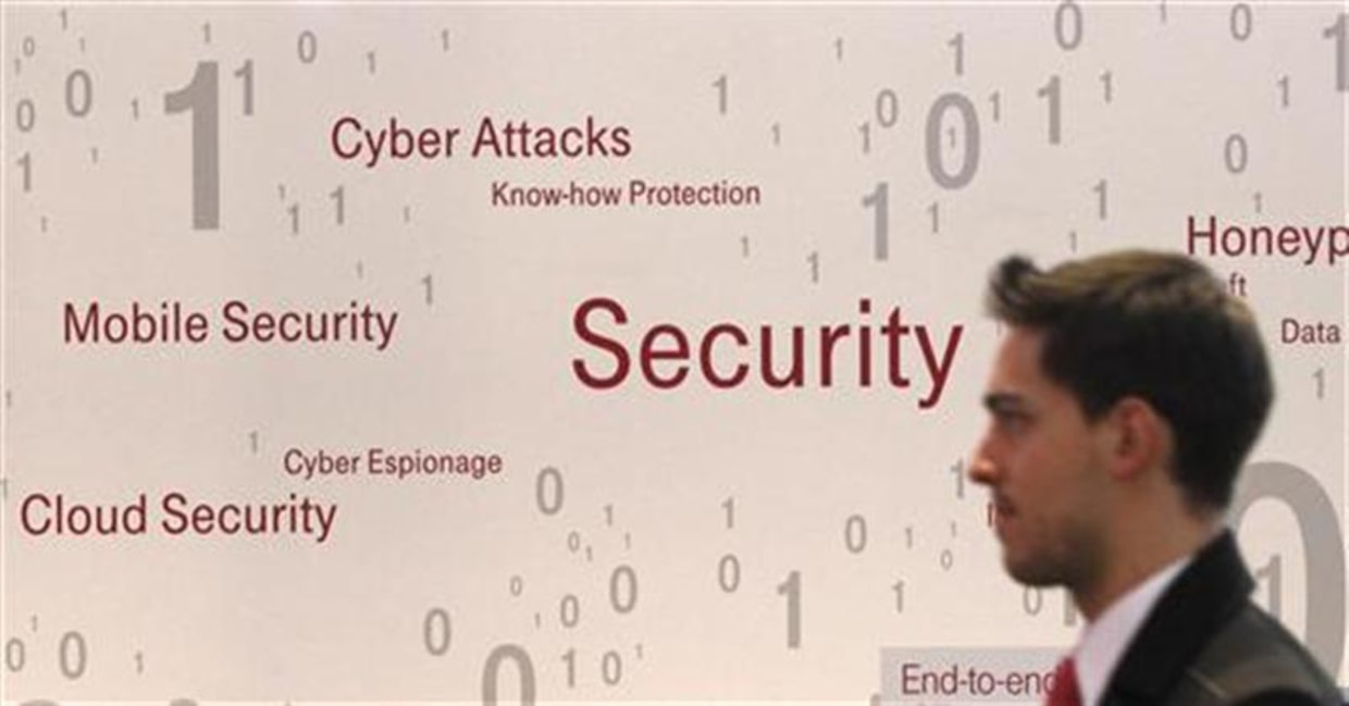 A visitor walks past an advertising billboard for security software application at the CeBit computer fair in Hanover