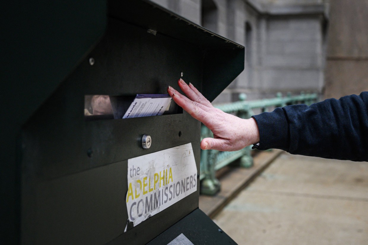 A voter casts their ballot at a drop box at Philadelphia city hall on Oct. 24, 2022.