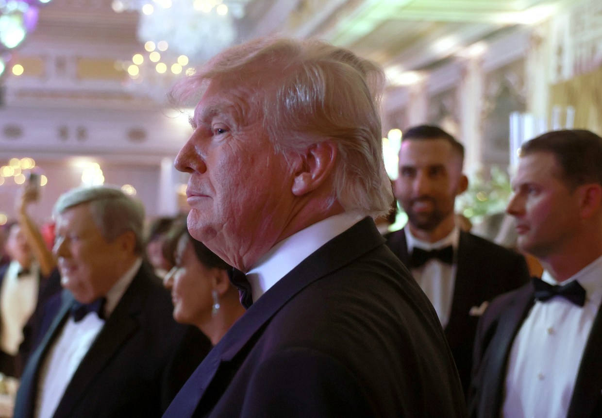 Donald Trump greets people as he arrives for a New Years event at his Mar-a-Lago home in Palm Beach, Fla.