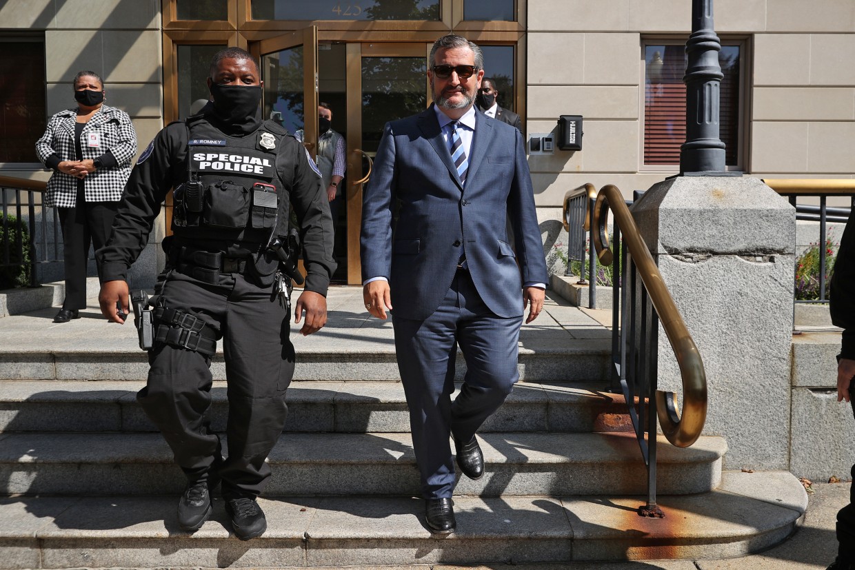 Ted Cruz is escorted by private security guards as he leaves the National Republican Senatorial Committee offices in Washington