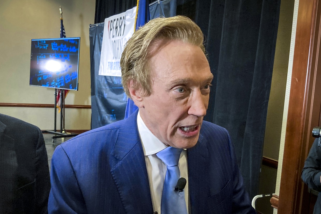 Michigan gubernatorial candidate Perry Johnson, a Republican, briefly speaks with reporters, on Feb. 23, 2022, after a kickoff event at a hotel in Lansing, Mich.