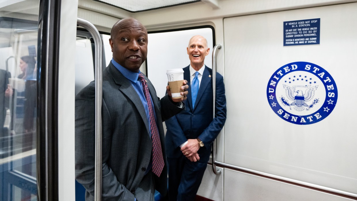 Tim Scott, left, and .Rick Scott board the Senate subway in the Capitol