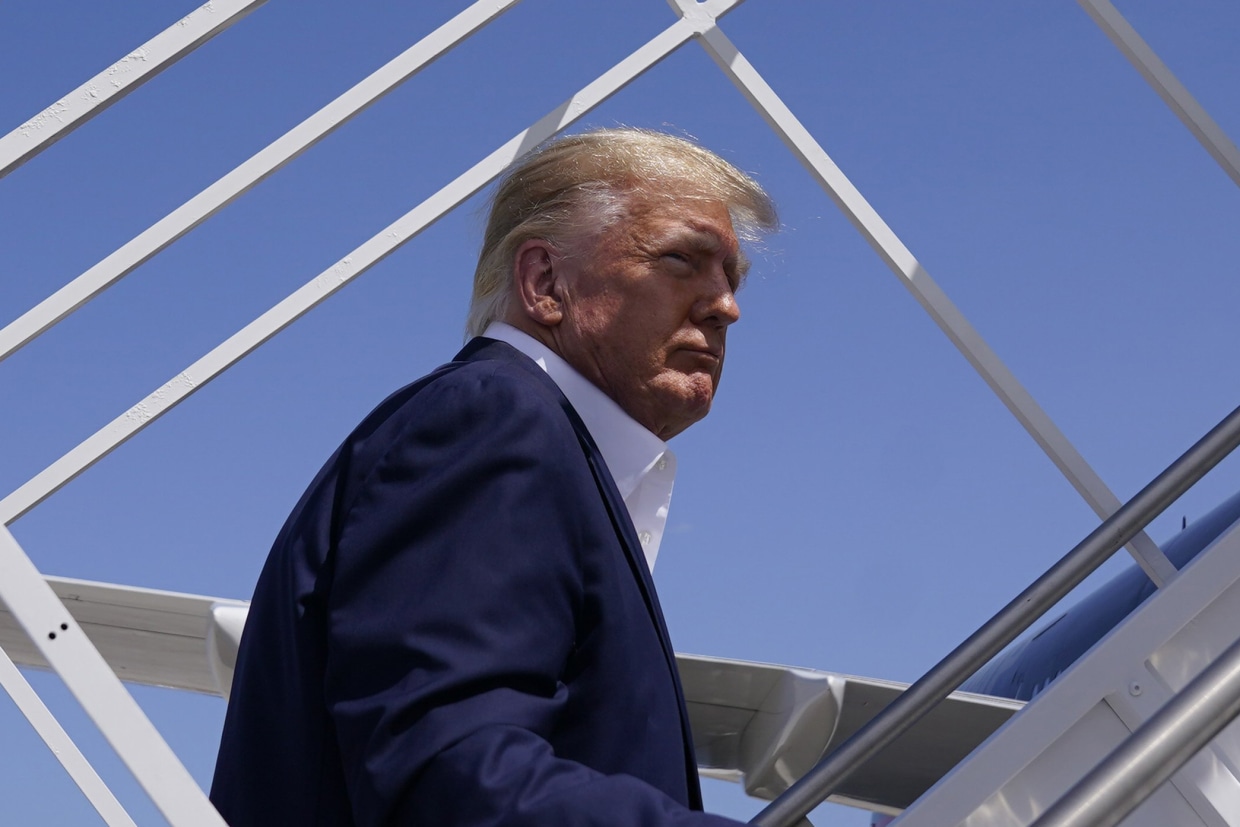 Former President Donald Trump boards his airplane to a campaign rally in Waco, Texas, on March 25, 2023, in West Palm Beach, Fla.