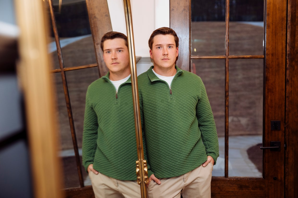 Jace Curry poses for a portrait next to a mirror reflecting him