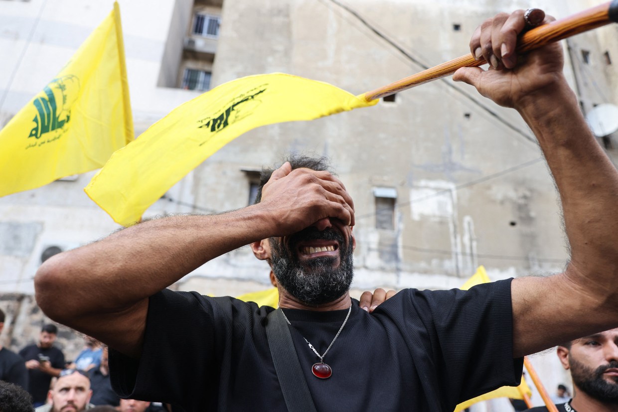 A man attends the funeral of people killed after hundreds of paging devices exploded in a deadly wave across Lebanon the previous day, in a south Beirut district, on Wednesday.