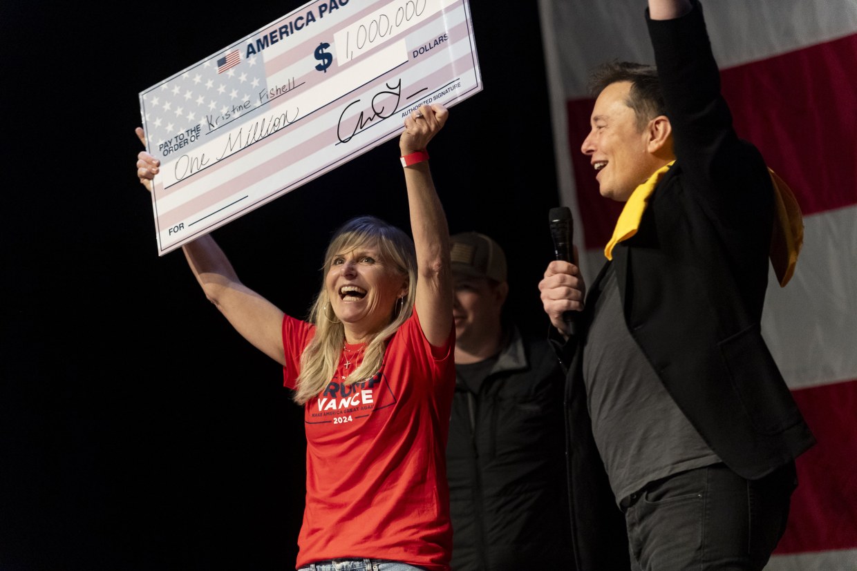 Elon Musk awards Kristine Fishell with a $1 million check during a town hall Saturday in Pittsburgh.