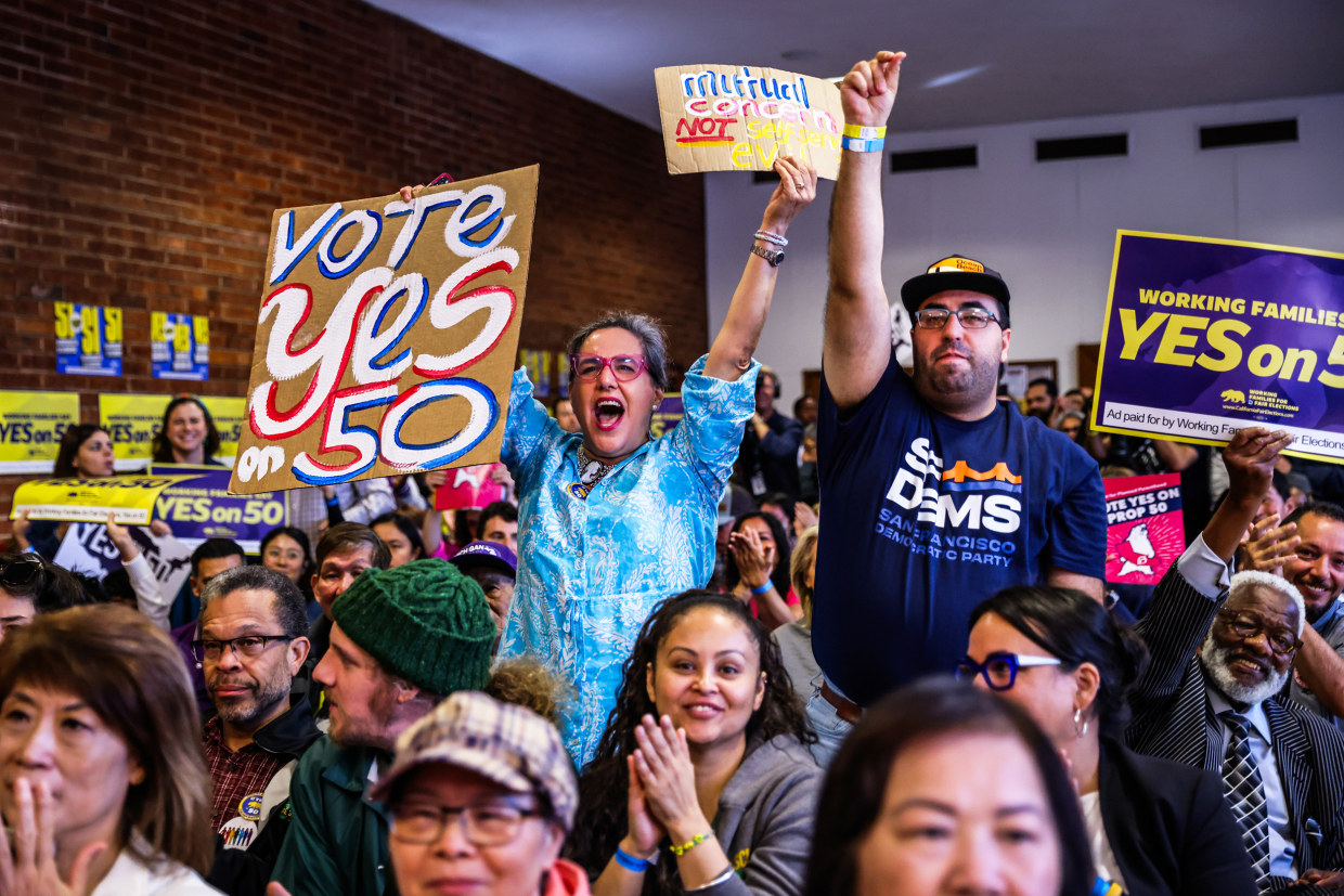 People cheer during a campaign event in support of Prop 50 in San Francisco.