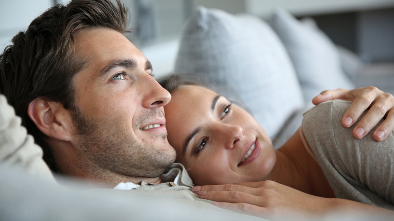 Man is unfastening bra to his woman lover before sex on bed Stock Photo