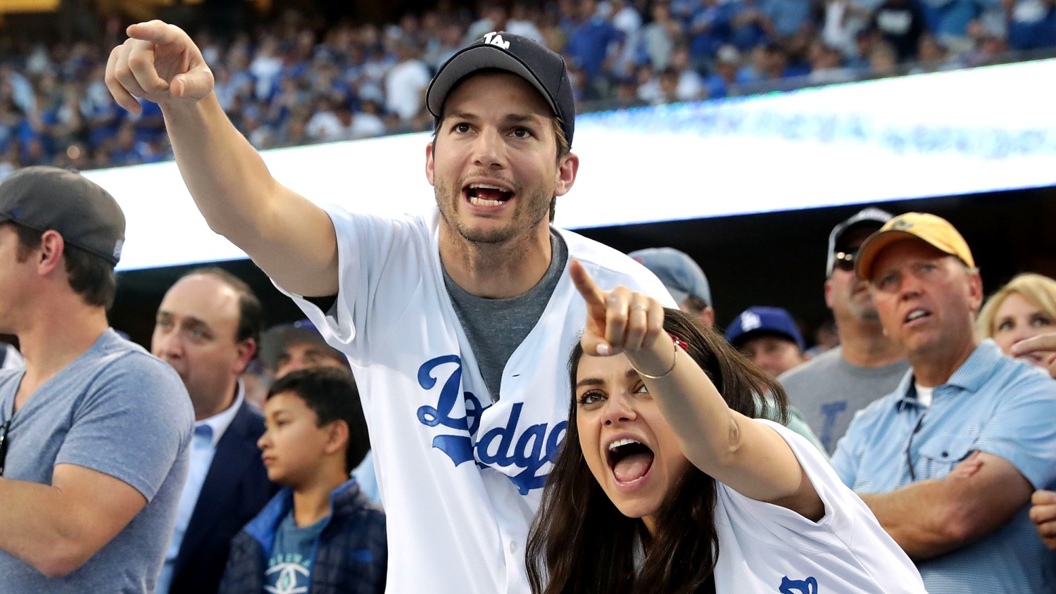 Pregnant Mila Kunis and hubby Ashton Kutcher put on PDA in matching outfits  at LA Dodgers crucial playoff game