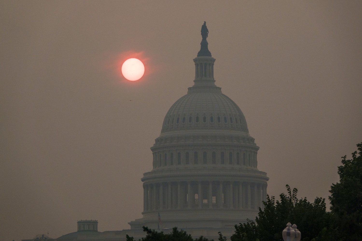 A darkened view of Washington D.C landmarks shrouded in heavy orange smoke