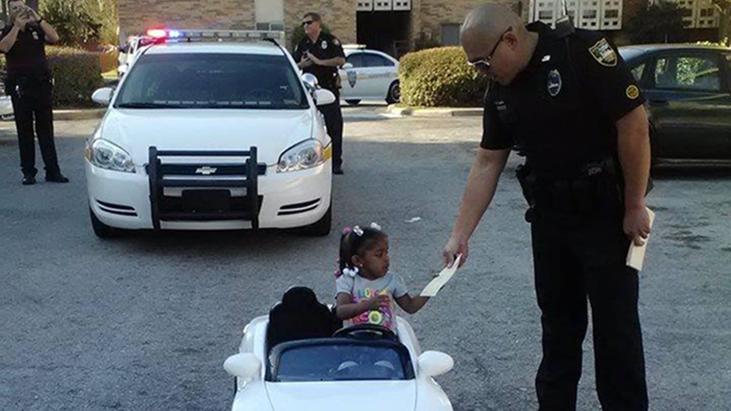 Photo of toddler in toy convertible getting ticket from cops goes viral