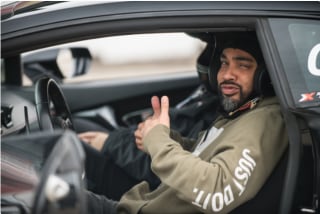 a man in a xtreme xperience race car with the double thumbs up