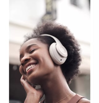 Woman smiling with Beats Pro Wireless Headphones.