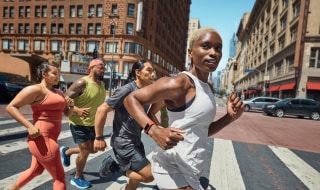 Group of people running in the street wearing Fitbit Charge 6 smart watches.
