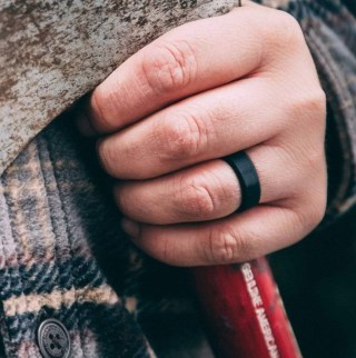 Hand wearing Manly Bands The Best Man black silicone band. 