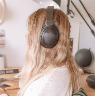 Woman with dirty blond hair wearing Puro Sound Labs PurePro headphones. 