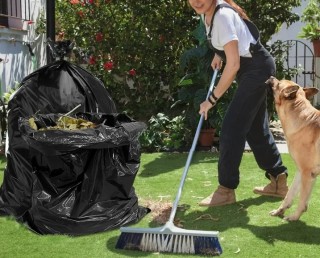 Woman raking leaves into trash bags