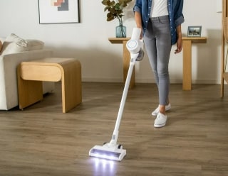 Cordless stick vacuum in use on hardwood floor