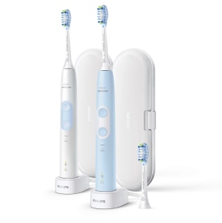 a photo of two light blue and white electric toothbrushes from Philips