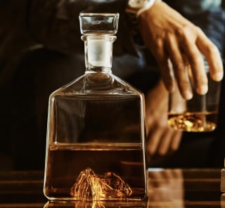 a photo of a whiskey decanter with a caramel colored whiskey in it