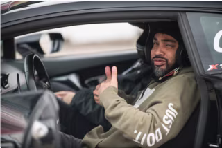 a man in a xtreme xperience race car with the double thumbs up