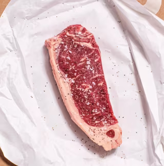 Porter Road NY Strip Steak seasoned on paper