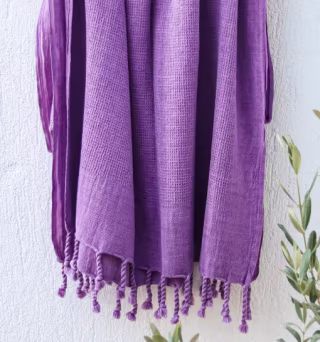 photo of a purple waffle-wave Turkish towel dangling in air