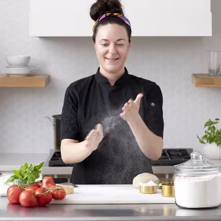 Photograph of a chef cooking pasta and sauce
