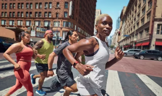 Group of people running in the street wearing Fitbit Charge 6 smart watches.
