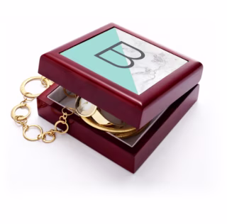 Shutterfly monogram box with B on top and gold jewelry coming out of the box