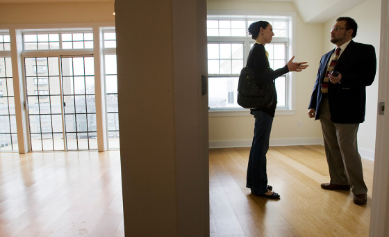 Image: Prospective home buyer Jessica Doctoroff talks to her real estate agent Stephen Bremis (R) while viewing a condominium for sale in Somerville, Mass.