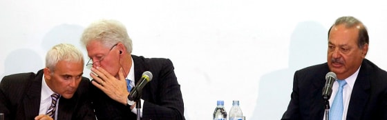 Image: Canadian mogul Frank Giustra (L) speak with US former President Bill Clinton (C) accompanied by Mexican Carlos Slim (R)