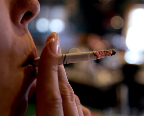 An employee takes a drag on a cigarette at Morgan's Place bar and restaurant in Harrisburg, Pa. Tobacco users are facing a big hit this week as the single largest federal tobacco tax hike takes effect. 