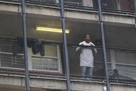 Image: A resident watches as movers, hired by the Chicago Housing Authority, remove another resident's belongings from the last high-rise of Chicago's Cabrini Green public housing project