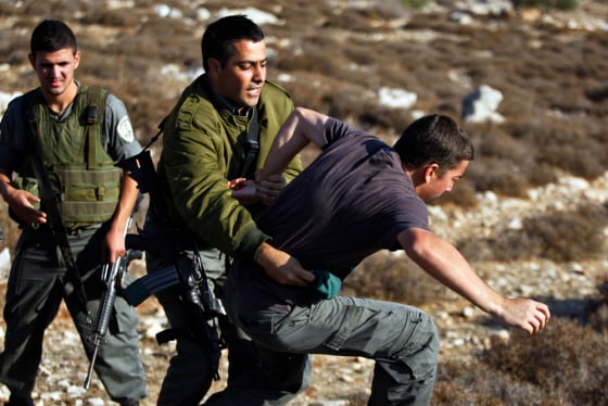Israeli border police officers scuffle with a Jewish settler during an attempt to arrest him Monday next to the outpost of Migron, near the West Bank city of Ramallah.