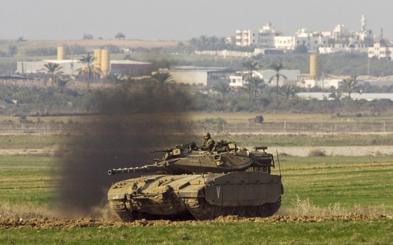 Image: An Israeli tank drives a long the border with the Gaza Strip