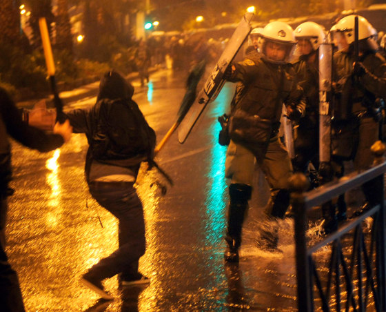 Image: A demonstrator clashes with police outside the U.S. Embassy in Athens