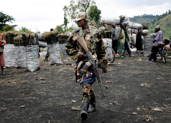 Image:A CNDP rebel walks through the charcoal market in Rupango