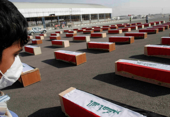 Image:A morgue worker stands near the coffins of Kurdish victims