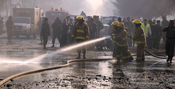 Image: Afghan firefighters wash the road at the site of a suicide attack in Kabul