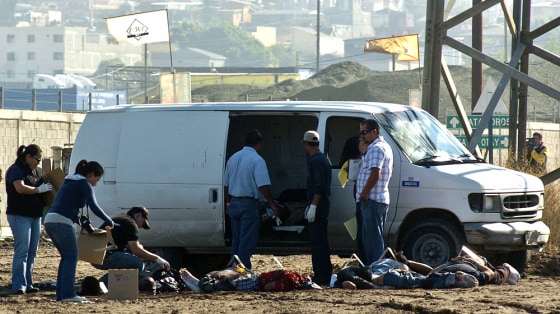Image: Mexican police officers search the area of nine beheaded bodies found in Tijuana city