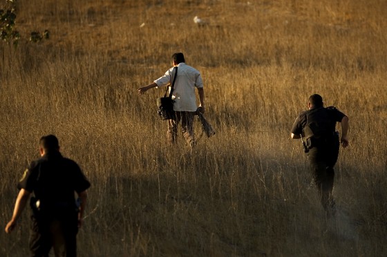 Police officers run after a photographer trying to reach a better view of a crime scene where a police officer was killed in Rosarito, Mexico, on Oct. 23. Mexico is the deadliest place in the Americas to be a journalist, and among the most dangerous in the world.