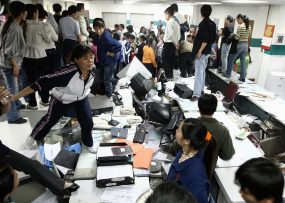 Image: Factory workers smash an office during a protest at Kaida toy factory in Dongguan,
